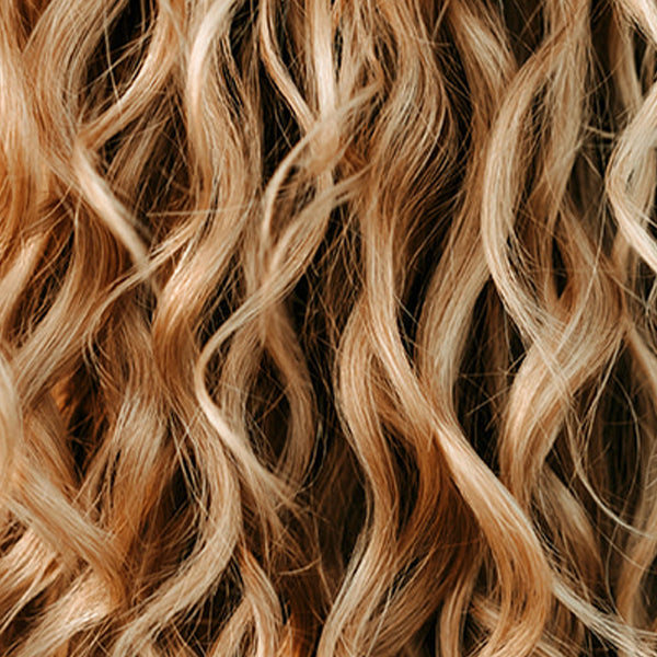Blonde wavy hair with sun shinning on it from behind