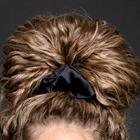 Close-up of MoonstoneSeven satin scrunchie securing curly hair for a gentle, frizz-free hold