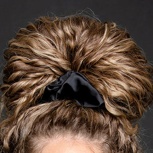 Close-up of MoonstoneSeven satin scrunchie securing curly hair for a gentle, frizz-free hold