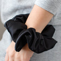 MoonstoneSeven satin scrunchie worn on wrist as a soft and stylish hair accessory