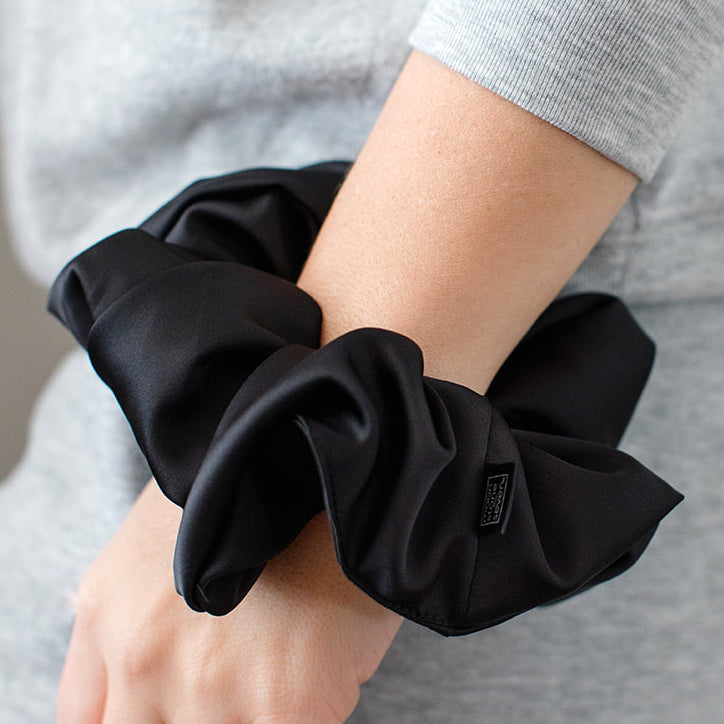 MoonstoneSeven satin scrunchie worn on wrist as a soft and stylish hair accessory