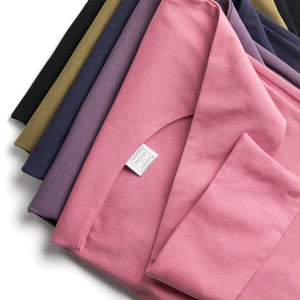 An upclose detailed image of the folds of the fabric. Having the plops folded in a pile with mauve being the focal point on top