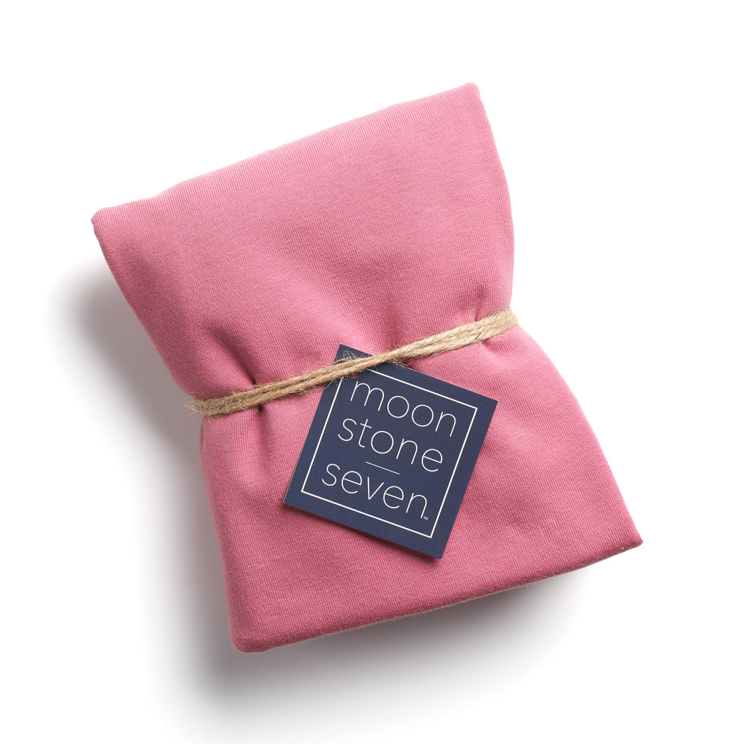 Mauve hair plop towel folded with MoonstoneSeven navy product tag and tied with twine
