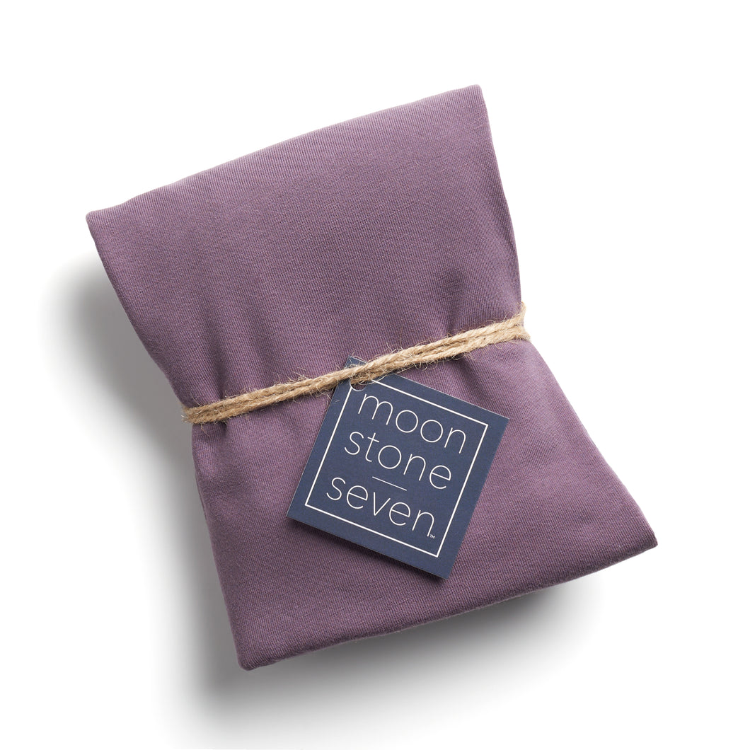 Plum hair plop towel folded with MoonstoneSeven navy product tag and tied with twine